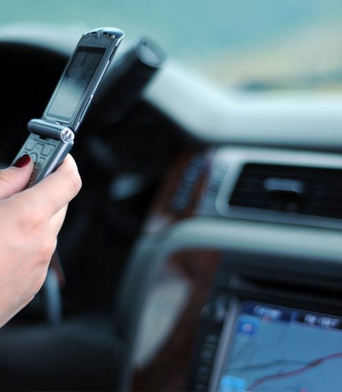 personne avec téléphone dans les mains au volant