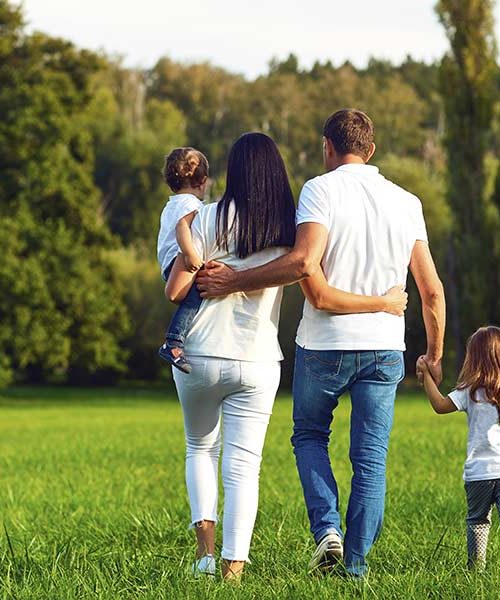 famille de dos se promenant dans un espace vert